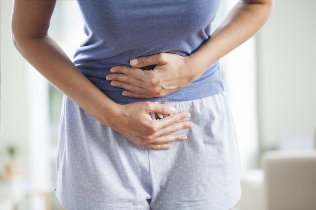 下腹部を押さえる女性