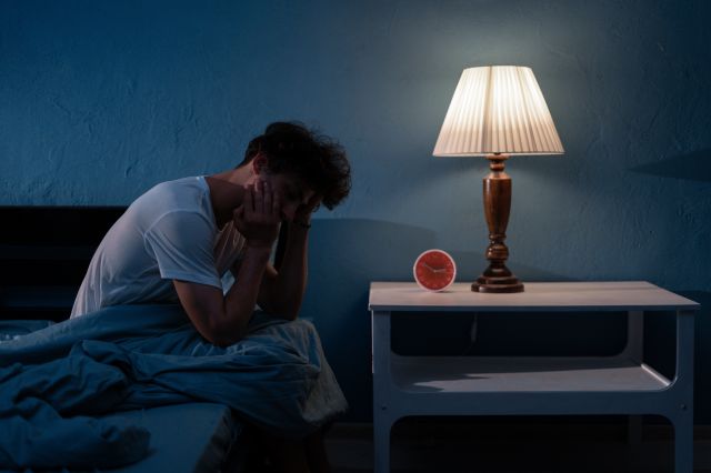 暗い部屋で悩む男性