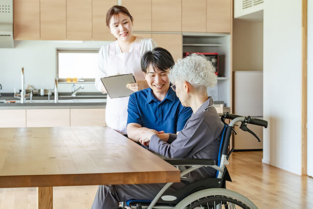 ケアスタッフからサポートを受ける車椅子に乗ったシニア女性