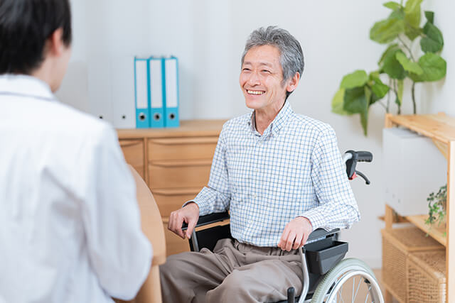 医者と話す高齢の患者(車椅子)